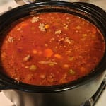 Bowl of pasta fagioli soup with kidney beans, ditalini pasta, carrots, ground turkey, spinach, and herbs in a tomato broth.